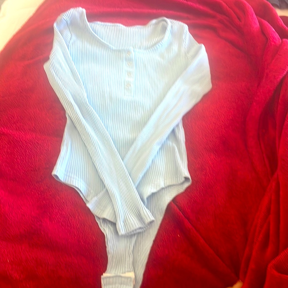 The  bodysuit is baby blue it shows white but it’s a beautiful baby blue